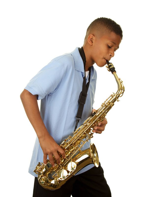 Boy playing the saxophone after learning to play from online free music lessons