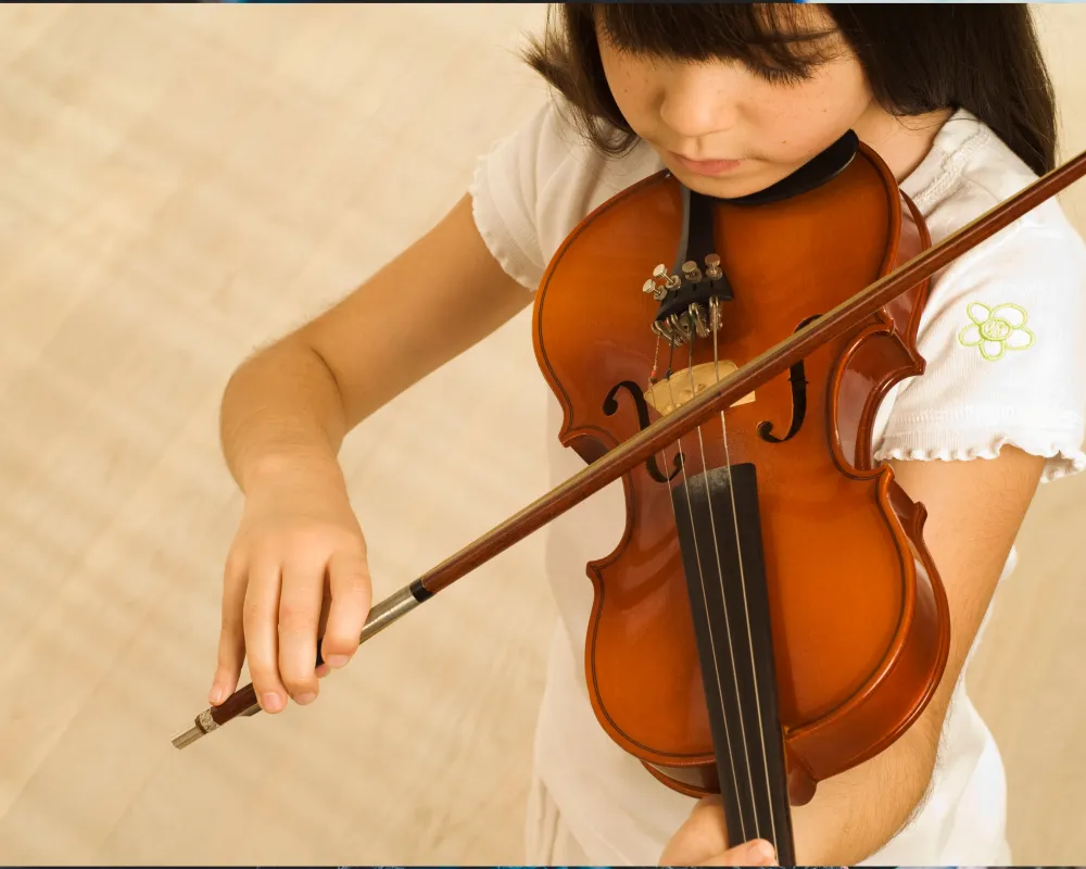 Homeschool child practicing instrument in morning light – perhaps sitting at a piano or holding a small instrument like a violin Homeschool child practicing instrument in morning light, Structuring Homeschool Music Lessons
